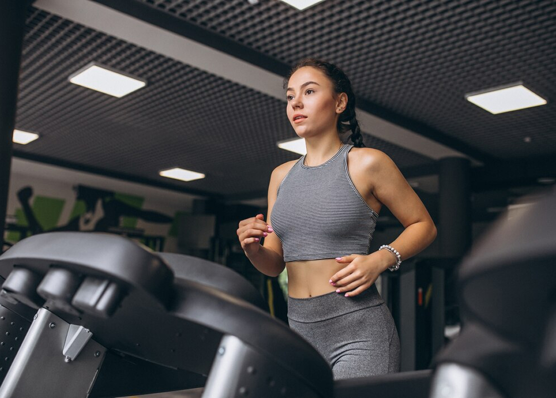 Велотренажеры в спортивном зале вдоль окна