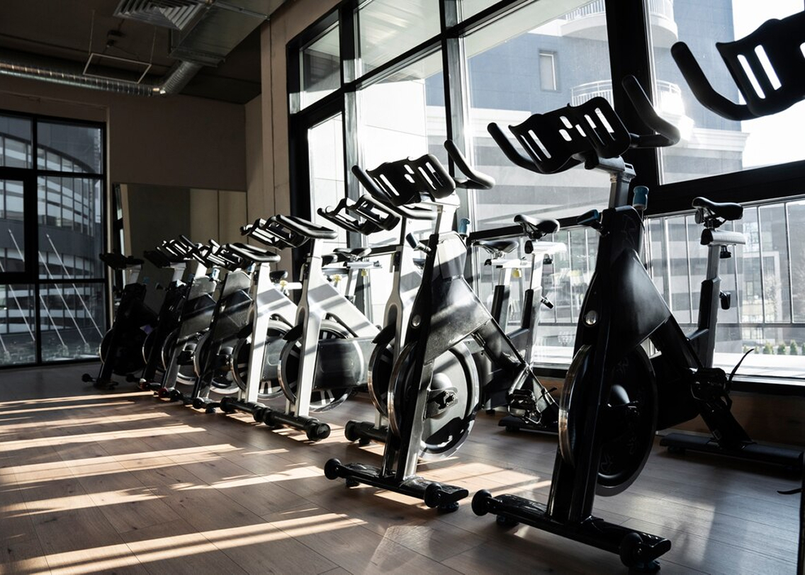 Велотренажеры в спортивном зале вдоль окна